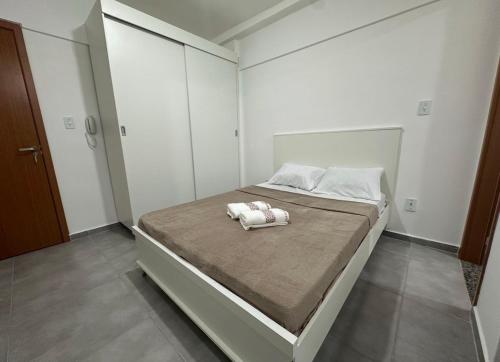 a bedroom with a large bed with two towels on it at Studio Blanc - Espaço e conforto com uma vista incrivel in Barbacena