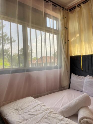 a bed in a room with a large window at Casa Bnb kisumu in Kisumu