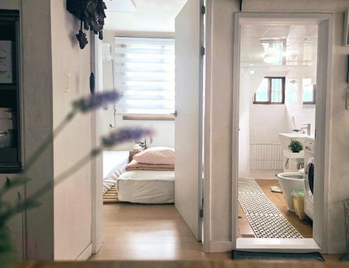 a door leading to a bedroom with a bed at Como Green House in Busan