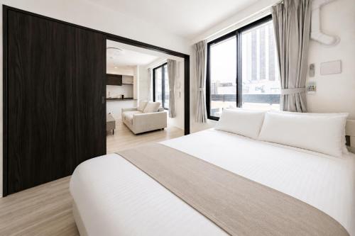 a bedroom with a white bed and a large window at Morikoya Hotel in Tokyo