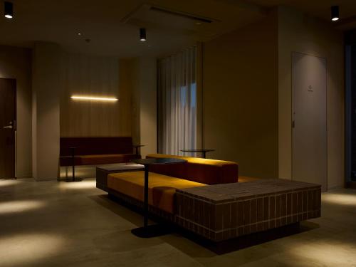 a room with a bed and a couch in a building at SMART PLACE iNN Hakata-Gion in Fukuoka