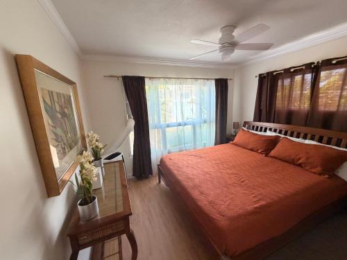 a bedroom with a red bed and a window at Laie Temple Hale in Laie
