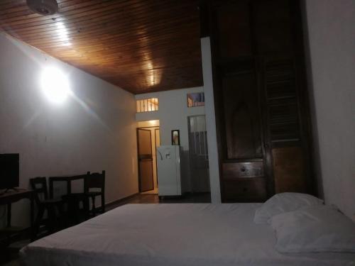 a bedroom with a bed and a table and a refrigerator at Aparta Studio Las Palmas in La Dorada