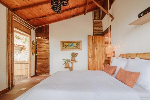 a bedroom with a large white bed and wooden ceilings at Mantoverde in Dosquebradas