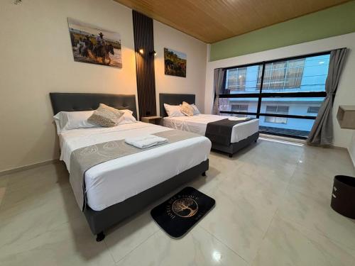 a bedroom with two beds and a large window at Hotel del Parque Arauca in Arauca