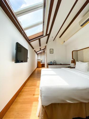 una camera da letto con un grande letto e una TV di The Sultan a Singapore