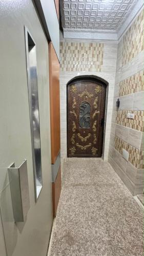 a large wooden door in a room with a hallway at بيّت الضيافة in Al Baha