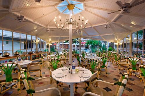 a restaurant with tables and chairs and a chandelier at Avion Holiday Resort in Lonavala