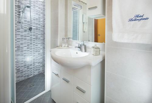 bagno bianco con lavandino e doccia di Hotel Bellerofonte a Rimini