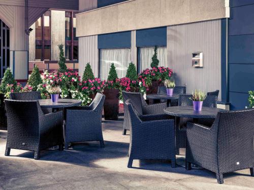 a patio with tables and chairs and flowers at Mercure Manchester Piccadilly Hotel in Manchester