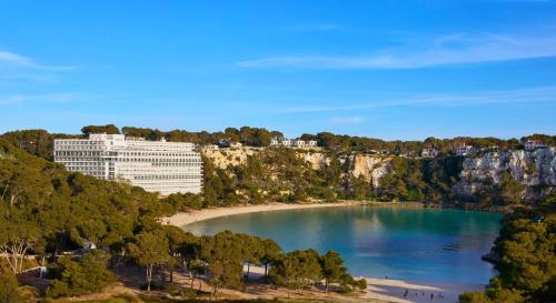 a large building on a hill next to a beach at Meliá Cala Galdana in Cala Galdana