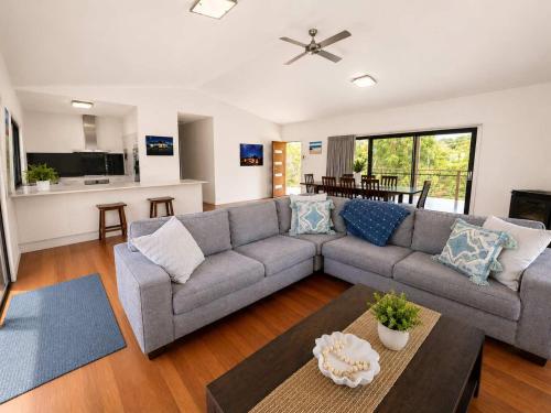 a living room with a couch and a table at Bawley Backyard Haven - family retreat near beach in Bawley Point