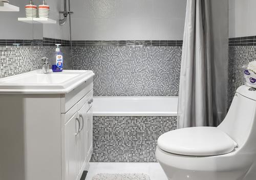 a bathroom with a toilet and a sink and a tub at Mountain Escape with Rooftop in Jūrat Arşūn