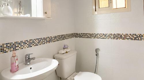a bathroom with a toilet and a sink at Mountain Escape with Rooftop in Jūrat Arşūn
