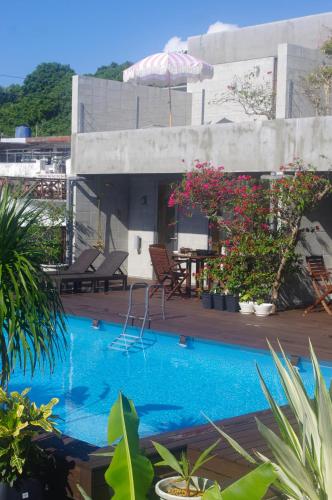 ein Schwimmbecken mit einem Tisch und einem Sonnenschirm in der Unterkunft mrsbutt inn in Aka