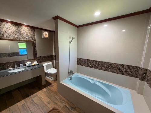 a bathroom with a tub and a toilet and a sink at Phi Phi Villa Resort in Phi Phi Islands