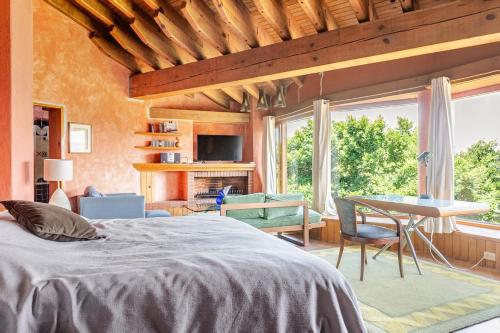 a bedroom with a bed and a table and a window at Rustic house with stunning lake view in Valle de Bravo