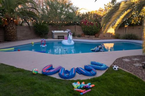 a swimming pool with inflatables in a backyard at Sparkling SaltwtrPoolSpaFirepitFreeNetflixWiFi in Phoenix