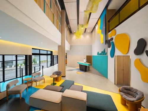 a waiting room with couches and a table at Quest Vibe Dewi Sri Bali in Legian