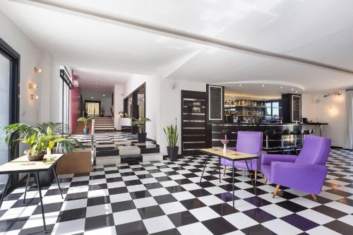 a lobby with purple chairs and a checkered floor at Hotel Eetu Begur, Affiliated by Meliá in Begur
