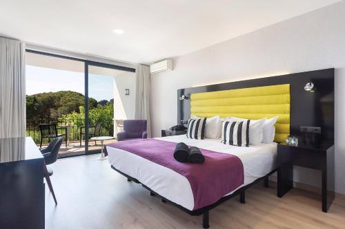 a bedroom with a large bed with a yellow headboard at Hotel Eetu Begur, Affiliated by Meliá in Begur