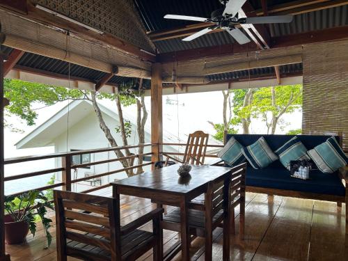 a dining room with a table and a couch at Txaleta de Camiguin desde 2024 in Mambajao