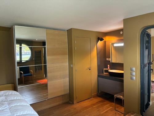 a bedroom with a bed and a bathroom with a sink at Peniche Casa Luze in Issy-les-Moulineaux