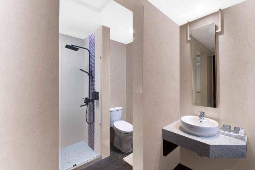 a bathroom with a shower and a sink and a toilet at Oakwood Merdeka Bandung in Bandung