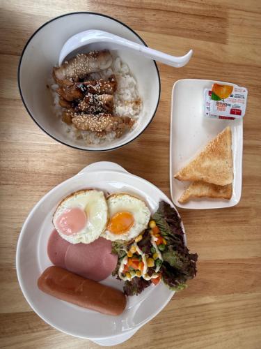 two plates of food with eggs and bread on a table at Albus resort Kohlarn in Ko Larn