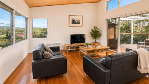 a living room with two couches and a television at Anchor at Bawley in Bawley Point
