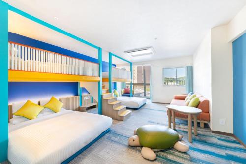 a bedroom with two beds and a desk and a couch at Spa Resort Hawaiians Hotel Hawaiians in Iwaki