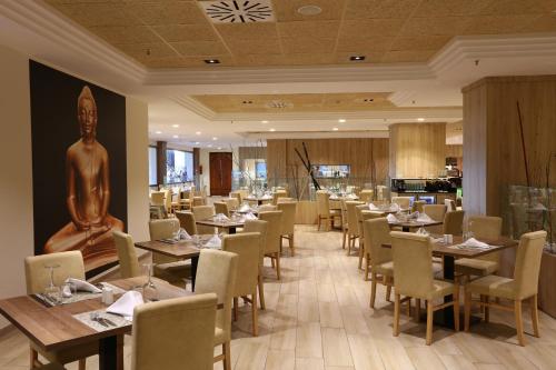 a dining room with tables and chairs and a statue at Sandos Papagayo in Playa Blanca