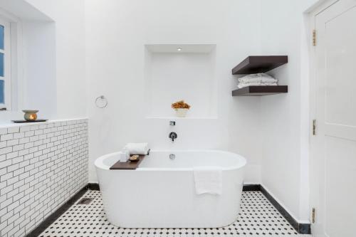 a white bathroom with a tub and a sink at Villa Lé Maas Tota by 98 Acres in Koslanda