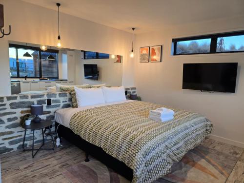 a bedroom with a bed and a flat screen tv at Simply Stunning Stars B in Lake Tekapo