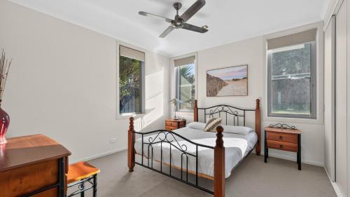a bedroom with a bed and a ceiling fan at Nautilus - Modern Lakeside Escape in Lakes Entrance