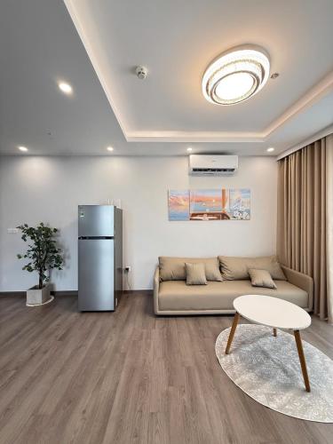 a living room with a couch and a refrigerator at The Ruby Hạ Long in Ha Long