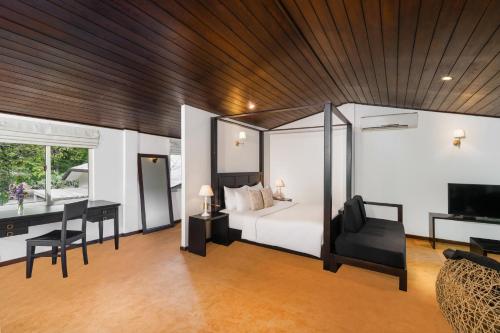 a bedroom with a bed and a desk and a computer at Villa Lé Maas Tota by 98 Acres in Koslanda