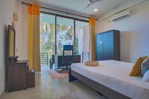 a bedroom with a bed and a desk and a television at Tranquil Heaven Near Galle & Unawatuna Quiet Stay & Fast WiFi in Galle