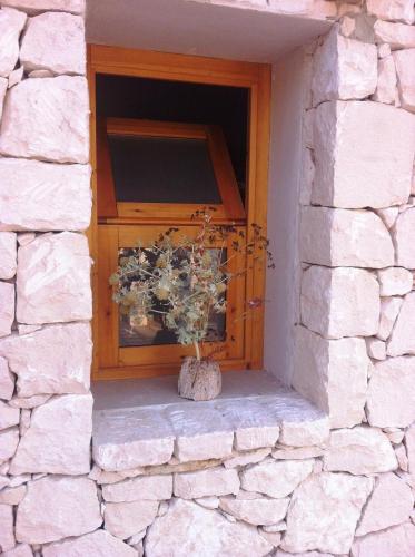a window in a stone wall with a plant in a vase at Casa Bedda in Noto Marina