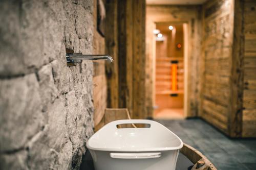 a bathroom with a toilet in a stone wall at Lüch de Costa in Colfosco