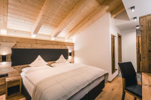 a bedroom with a large bed and a desk at Lüch de Costa in Colfosco