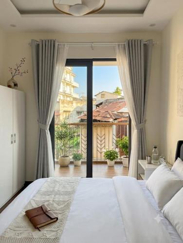 a bedroom with a large bed and a large window at An Phát Villa Đà Lạt in Da Lat