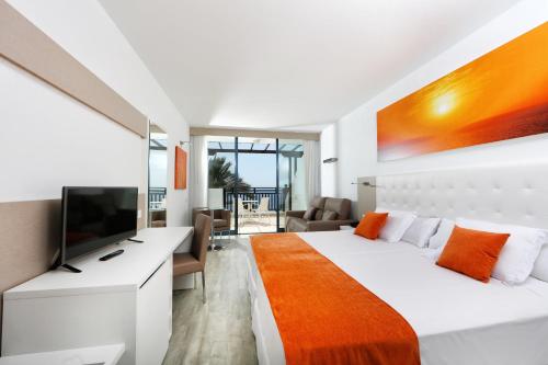 a bedroom with a large bed and a television at Sandos Papagayo in Playa Blanca