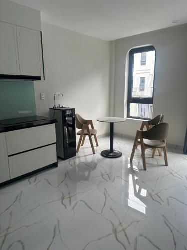 a kitchen with a table and chairs in a room at Flower Apartment in Buôn Enao