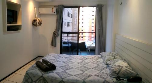 1 dormitorio con cama y vistas a un balcón en AP Top Condominio Porto de Iracema, en Fortaleza