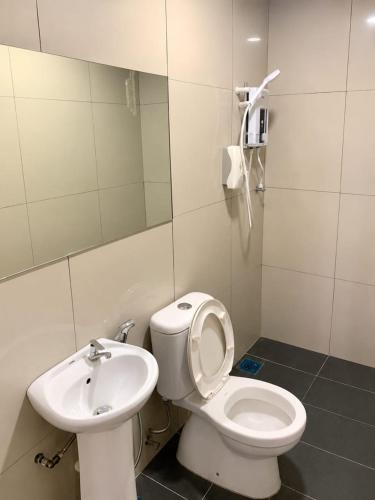 a bathroom with a toilet and a sink at Point Stay GH in Kuching