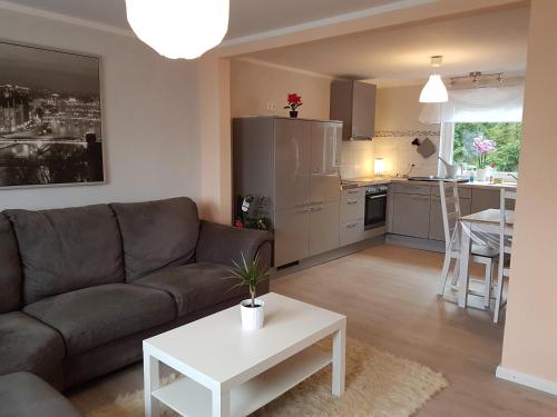 ein Wohnzimmer mit einem Sofa und einem Tisch in der Unterkunft Ferienhaus am Hasselberg Husum in Husum