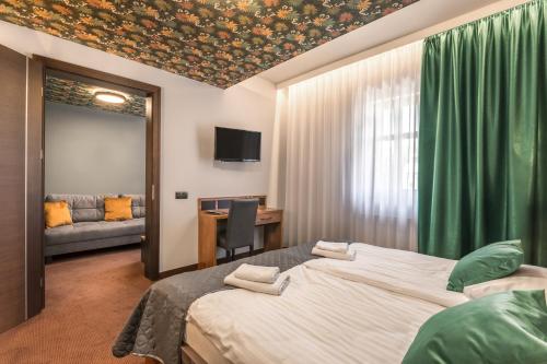 ein Schlafzimmer mit zwei Betten, einem Schreibtisch und einer Couch in der Unterkunft Brovar 16 in Pless