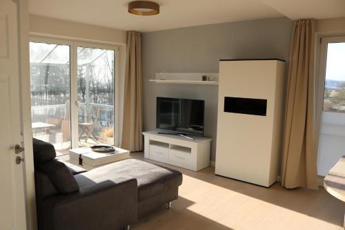 een woonkamer met een bank en een televisie bij Ostseezauber in Ostseebad Sellin