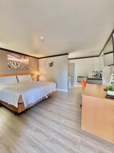 a bedroom with a large bed and a kitchen at Cascade Lodge Boutique in Bend